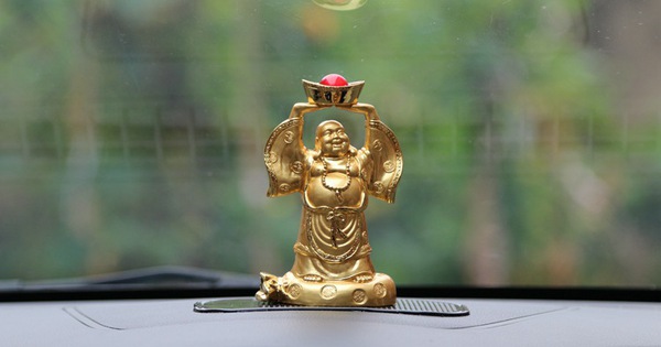 Placing a Buddha Statue on a Car for Good Luck and Peace